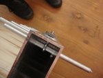 Schaftaufnahme - Exzenter(artige)Klemmung... Stift geht durch das Aluprofil (Holz geht auch), von oben hängt man durch ein Loch eine Ringschraube ins Profil. Spannt man die Mutter oben an zieht es den Stift hoch und er klemmt fest...